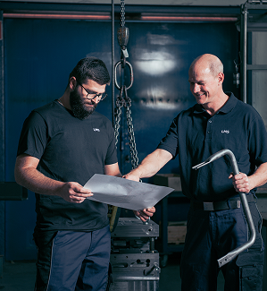 Mitarbeiter der LMS GmbH sprechen über den Prototyp des Haltegriffs mit einer technischen Zeichnung in der Hand