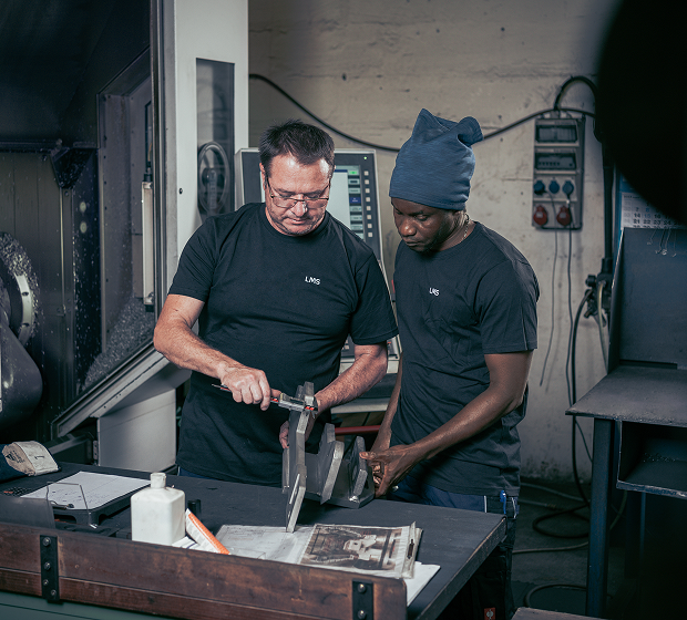 Zerspanungsmechaniker prüfen die Metallkomponente hergestellt für die Kinematik eines Bahnherstellers