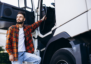 LKW-Fahrer beim Einstieg in seinen Truck, Fahrer hält sich an dem Einstiegsgriff des LKWs fest