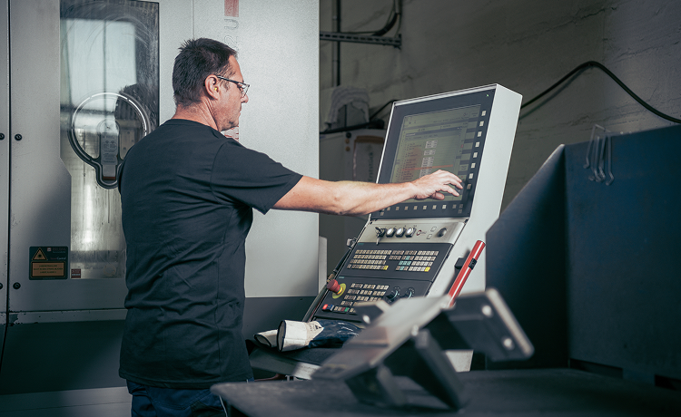 Zerspanungsmechaniker bedient eine CNC-Anlage