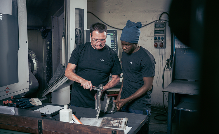 Zerspanungsmechaniker bei der Qualitätskontrolle einer gefertigten Metallkomponente