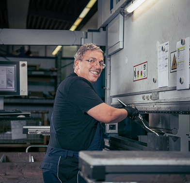 Fertigungsmitarbeiter beim Kanten eines Metallteils
