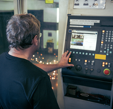 CNC-Anlagenbediener am Bedienpult der Laseranlage