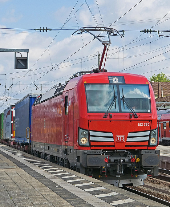 Vectron-Lok mit Güterwagen an einem Bahnsteig